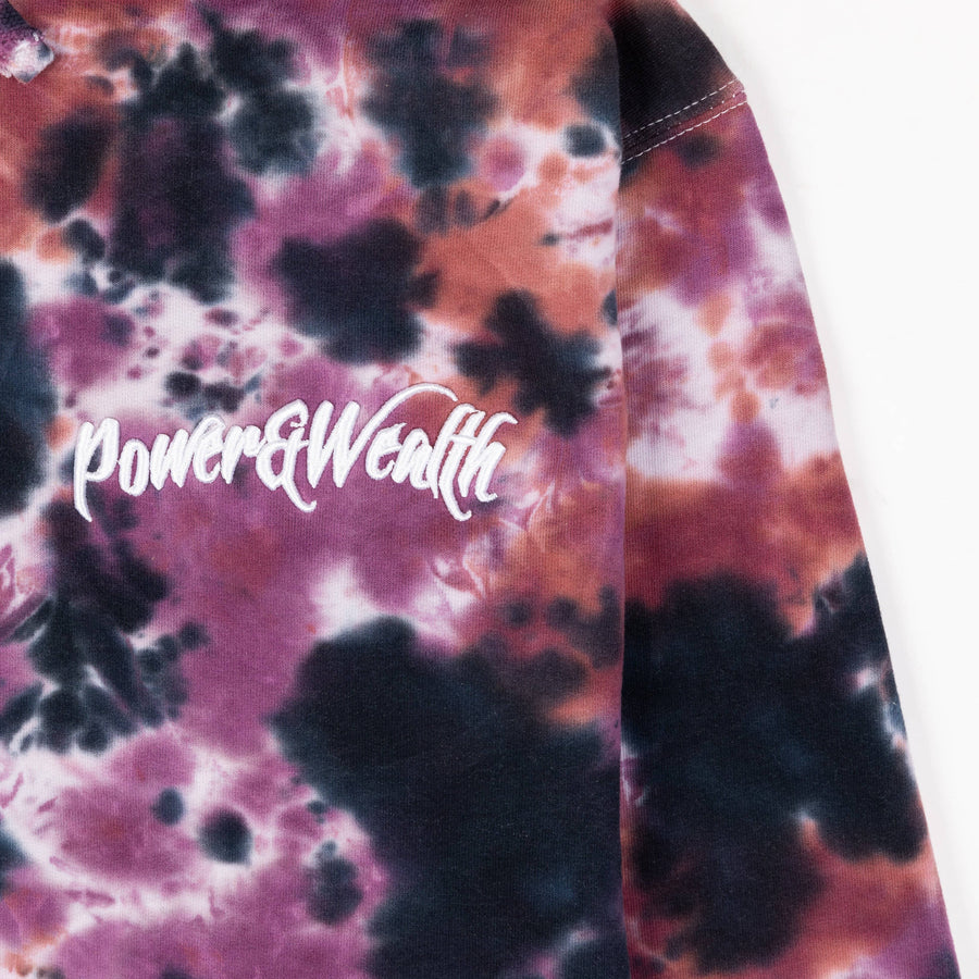 Close up image of the tie dye pattern hoodie with white embroidery on the front.